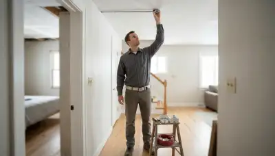 Technician measures ceiling placement for fire alarm devices in a Salt Lake City, UT home