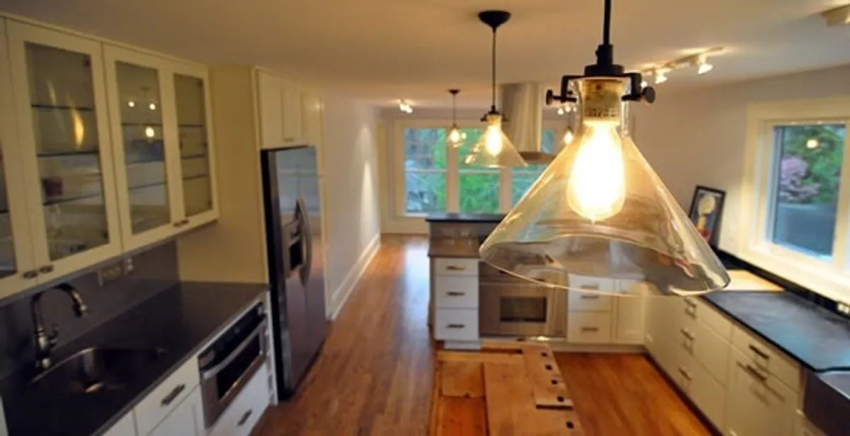 Residential electrician installing modern indoor light fixture in a home in Salt Lake City, UT