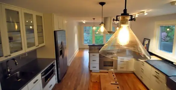 Residential electrician installing modern indoor light fixture in a home in Salt Lake City, UT