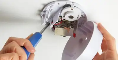 Certified technician wiring smoke detector during installation in Salt Lake City, UT